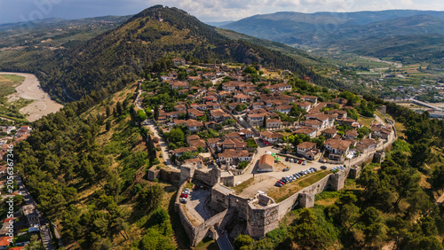 Aerial drone view of the historic Berat Castle and fortress in Albania. Panoramic cityscape of the ancient Ottoman town and stone citadel on a green hill