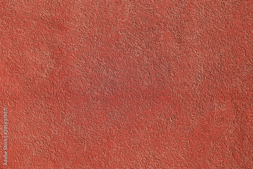 Fototapeta premium Textured background. Decorative plaster wall, external of facade. Texture of red pink peach fuzz stucco plaster wall of clay house structure background. Brown yellow clay mud cement texture pattern