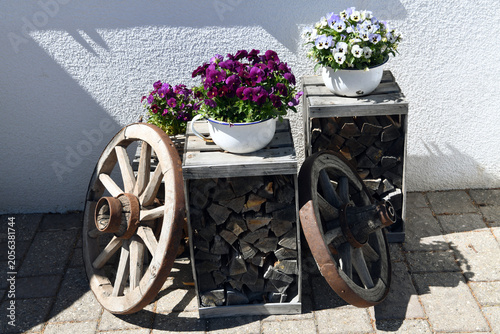 Rustic decorative composition featuring old wooden wagon wheels and enameled bowl-shaped flower pots in San Pietro Val di Funes south tyrol Italy
