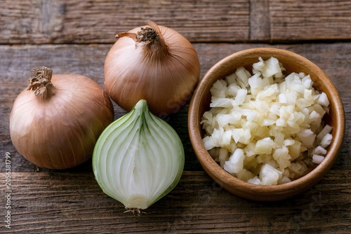 Fresh onions rest on rustic wood
