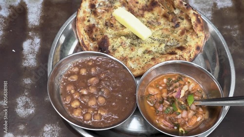Traditional Punjabi meal featuring spicy chole, flaky laccha paratha and onion chutney.
