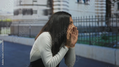Slika na platnu Woman with hands cupped to mouth shouting near building fence on street, hand on hip and pointing; frustration resolve