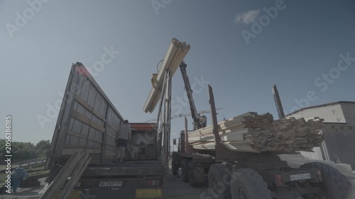 The process of loading wooden logs onto special equipment in the summer