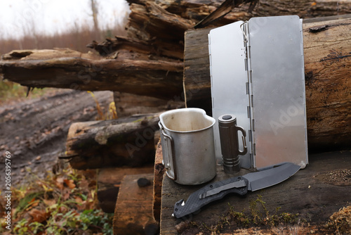 Foto Horizontal view of bushcraft camping gear setup on old logs in forest including