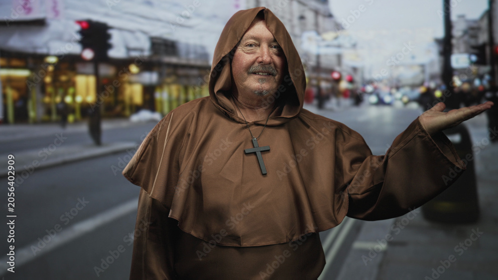 Obraz premium Senior man monk in brown robe with cross necklace presents open palm on a street; serenity welcome hospitality.