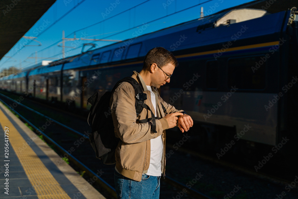 Obraz premium Man Waiting For Train With Backpack