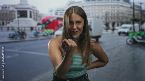 Photography Woman beckons with hand and strapless top visible on a street, arm on hip and choker accessory; playful invitation