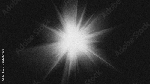 Bright starburst lens flare light effect on black background with grain texture.