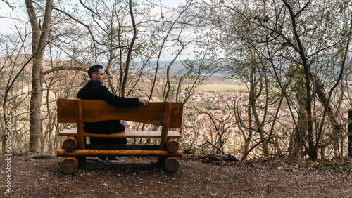 Man Sitting on Wooden Bench Overlooking Valley