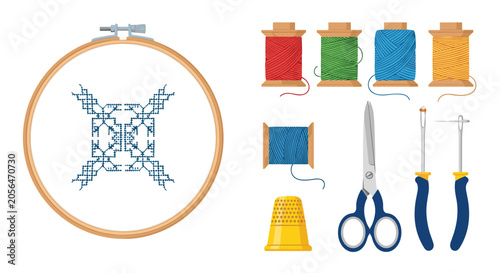 Creative embroidery kit with wooden hoop showing blue cross stitch pattern surrounded by colorful threads and sewing tools.