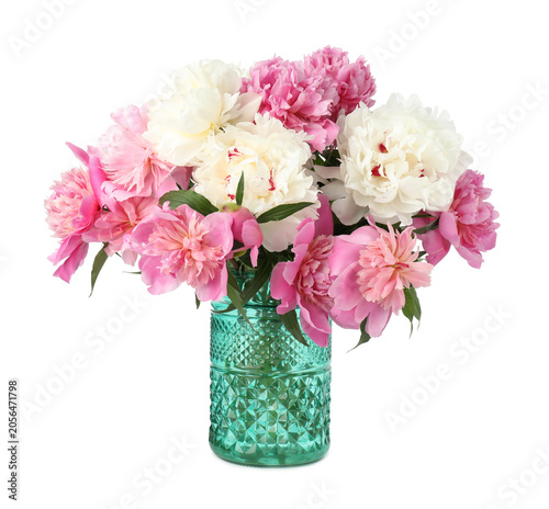 Bouquet of colorful peonies with green leaves in vase isolated on white