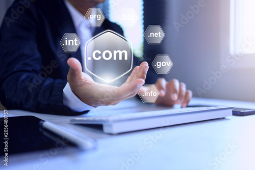 A businessman displays floating domain extensions above his hand, representing web address registration, online branding, website hosting, and global internet network concept
