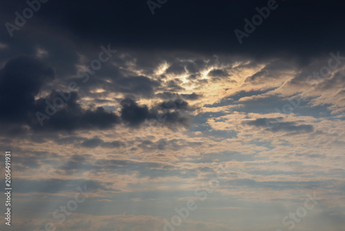 Bilde på lerret Dramatic evening sky with dark storm clouds pierced by golden sun rays