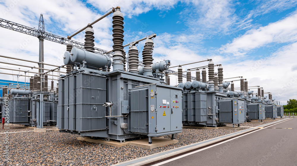 Obraz premium Power station transformers under a clear blue sky at midday