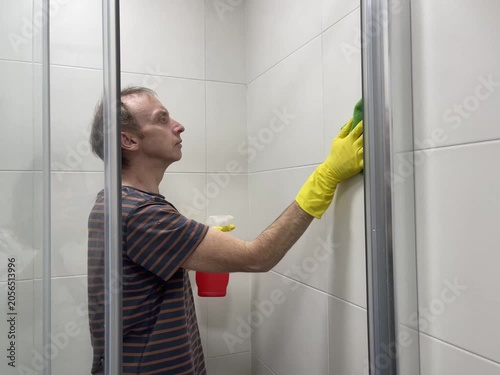 Man wearing protective gloves cleaning the bathroom