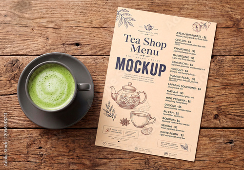 Blank flyer mockup beside cup on wooden table