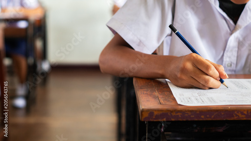 Foto Close-up of a student's hand diligently writing on an exam paper during a school test