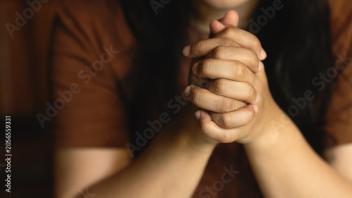 Obraz na plátne Woman holding hands together in prayer and meditation, front view, Christian worship, spiritual reflection, mindfulness, and seeking blessings in times of difficulty