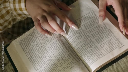young conservative asian Woman Reading the Bible at table with bread food and drink indoors