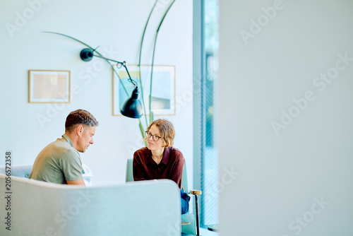 Foto Business colleagues discussing matters, collaborating and communicating in a modern bright office waiting area