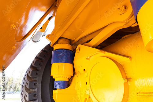 Tableau sur toile Tight close-up view of a yellow heavy-duty vehicle suspension assembly and adjacent wheel well