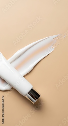 Minimal White Cosmetic Tube Resting on Cream Smear on Beige Background