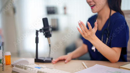 Fotografi Young Asian woman gesturing expressively while recording podcast episode with pr