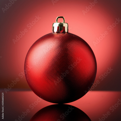 Red christmas bauble reflecting on festive background
