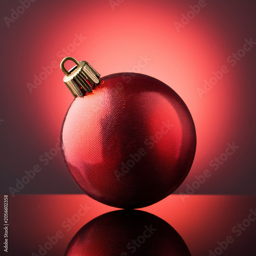 Red christmas bauble reflecting on festive red background