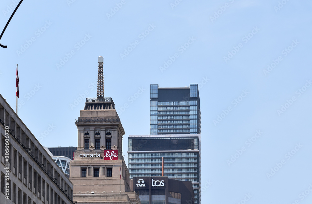 Naklejka premium Canada Life and Tata Consultancy Services signs displayed on the tops of office buildings along University Avenue in downtown Toronto, surrounded by modern high-rise commercial architecture, May 2026