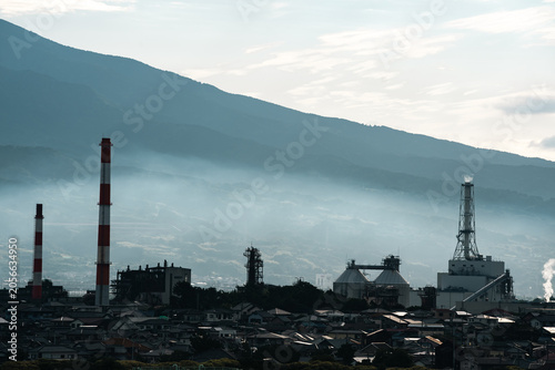 Industrial factory smokestack mountain fog city chimney pollution landscape plant industrial factory with smokestack near mountain slope, fog over city skyline, chimney tower, pollution haze