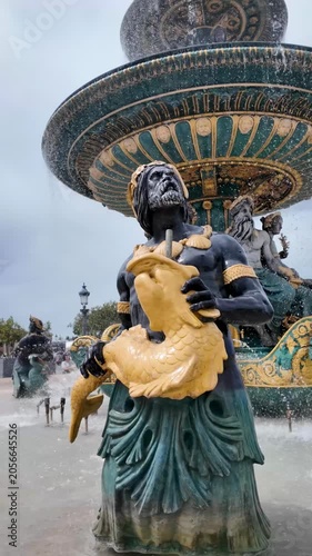 Ornate bronze sea god sculptures decorate baroque fountain in central Paris square