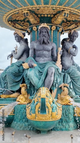 Ornate bronze sea god sculptures decorate baroque fountain in central Paris square