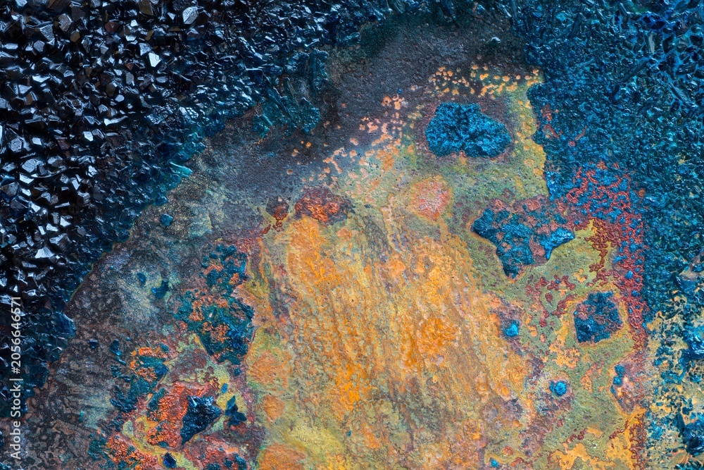 Fototapeta premium Abstract mineral texture with black crystals and colorful oxidation patterns, artistic geological background, macro surface detail