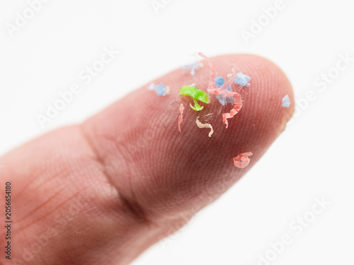 Trozos de microplásticos sobre un dedo de la mano