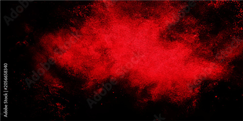 Tableau sur toile Explosion of vibrant red powder suspended in mid-air against a stark black backd