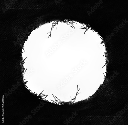 Burning black woven textile growing flame from small orange glow at studio macro Burned white fabric with black hole gap symbolizing lost hope broken connections Burn Hole on White Paper Background
