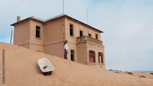 Woman visiting the abandoned town of Kolmanskop