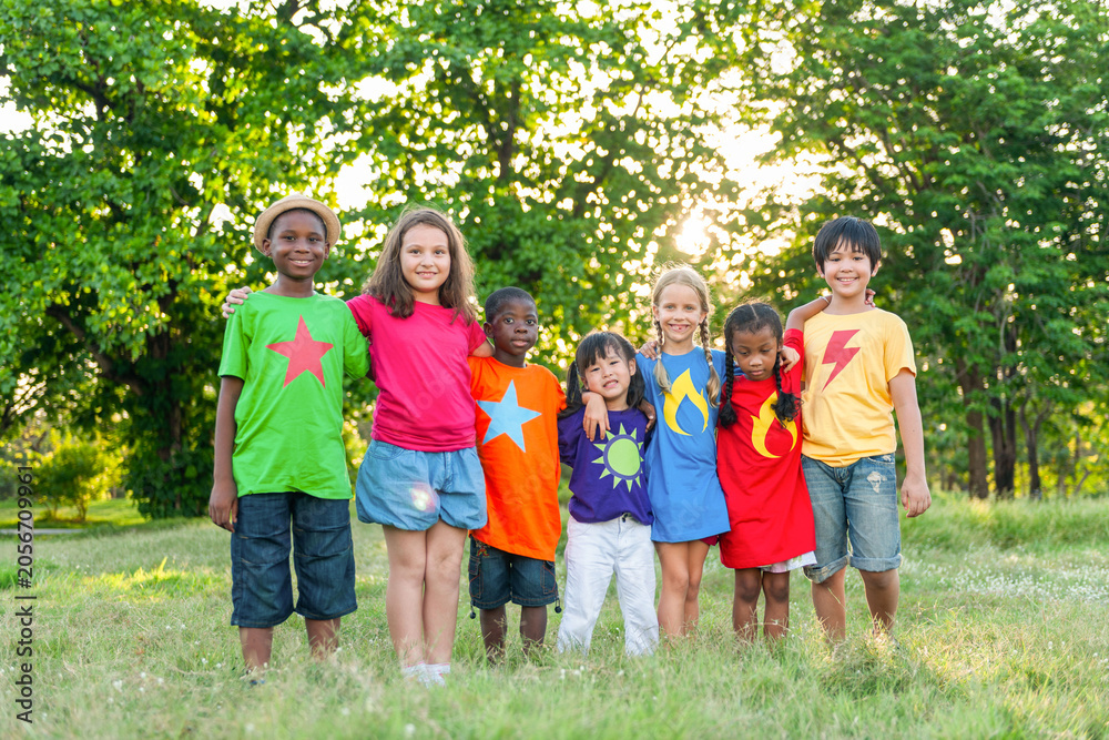 Fototapeta premium Diverse group of children in colorful shirts, smiling outdoors.
