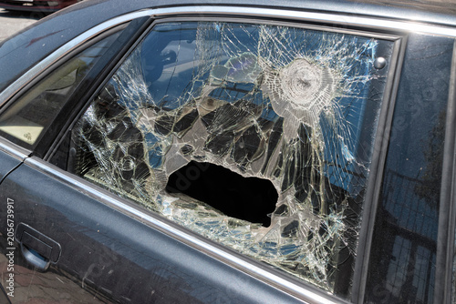 Severely shattered car side window with impact damage. Vehicle security concept.