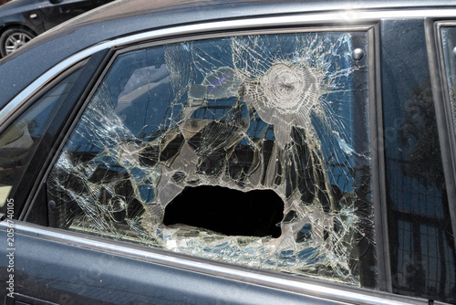Severely shattered car side window with impact damage. Vehicle security concept.