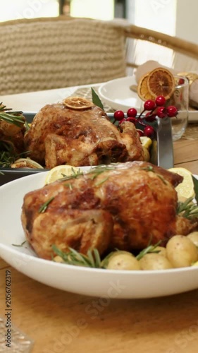 Vertical video: Panning shot from corn showing roast chicken bread citrus on dining table for feast