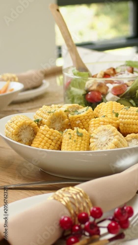 Vertical video: Corn bowl staying central as camera shifting, showing salad and napkin at home