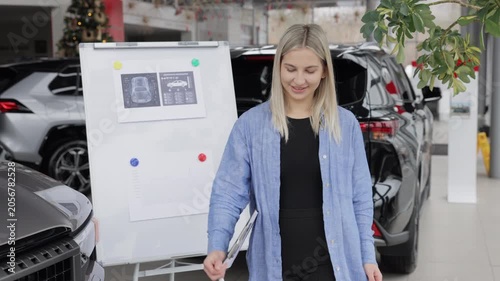 Saleswoman showing infographic during presentation about automotive suspension performance in car dealership