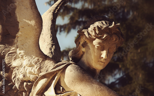 Quadro su tela Majestic angel statue illuminated by warm golden sunlight.