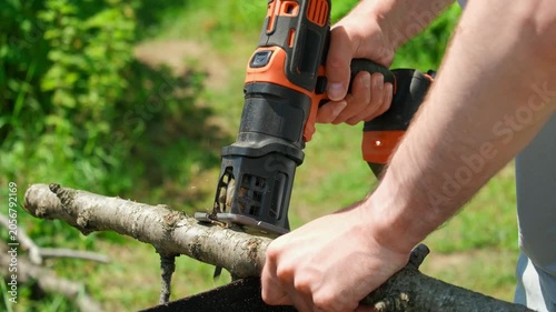A close-up of cutting a branch with a jigsaw