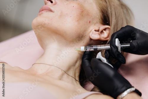 Картината върху платно Woman lying on a treatment bed receiving cosmetic injection in modern aesthetic clinic