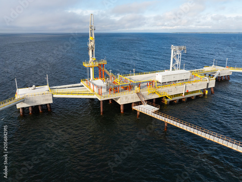 Aerial view of offshore LNG terminal jetty in the sea, marine natural gas unloading platform with pipelines, drone photography