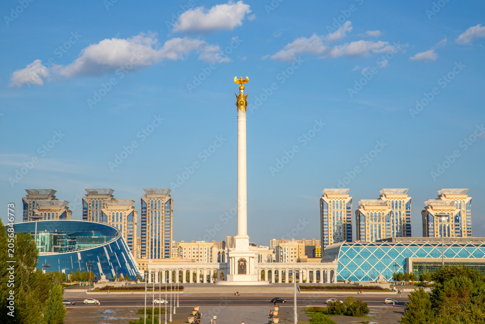 Naklejka premium Qazaq Eli monument on Independence Square in Astana. Tall white pillar with golden eagle statue. Landmark of Kazakhstan cityscape, architecture and tourism travel destination. 08.06.25