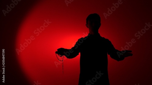 Canvastavla Man silhouette standing with arms outstretched, holding a rosary in one hand, il